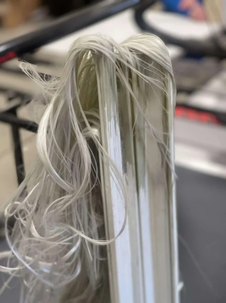 a white piece of fabric with long hair used in making fiberglass windows